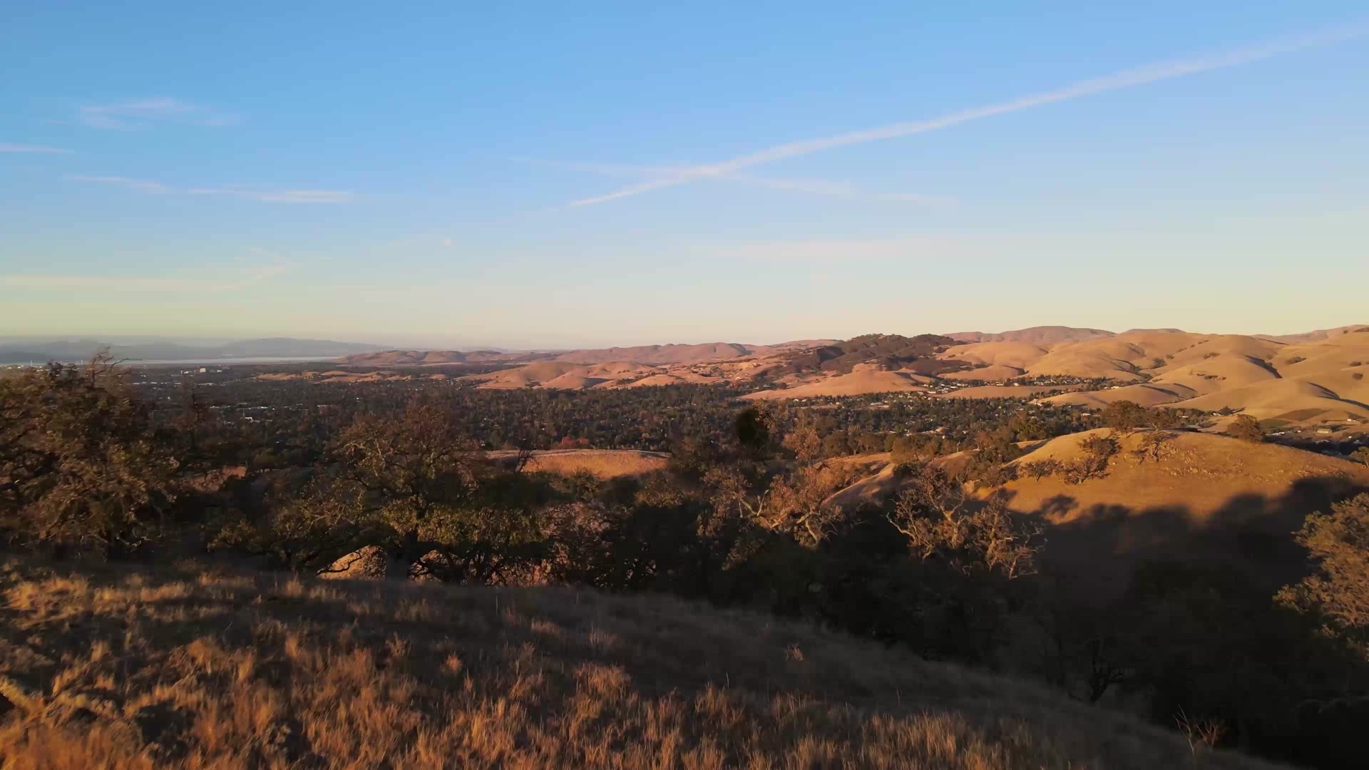 Golden South Bay hills above Silicon Valley neighborhoods at sunset, illustrative